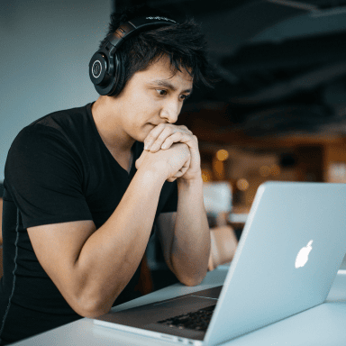 Man with headphone on looking at computer