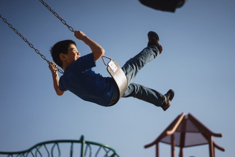Boy smiling while swinging